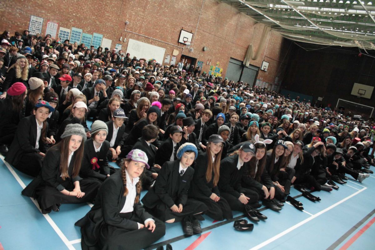 Large assembly of students in various headwear